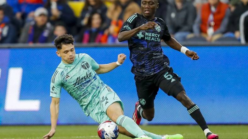 Apr 22, 2023; Cincinnati, Ohio, USA; Portland Timbers midfielder David Ayala (24) dribbles against FC Cincinnati midfielder Obinna Nwobodo (5) in the first half at TQL Stadium. Mandatory Credit: Katie Stratman-USA TODAY Sports