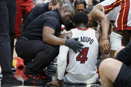 Apr 22, 2023; Miami, Florida, USA; Miami Heat guard Victor Oladipo (4) is checked on after an injury in the fourth quarter against the Milwaukee Bucks during game three of the 2023 NBA Playoffs at Kaseya Center. Mandatory Credit: Sam Navarro-USA TODAY Sports