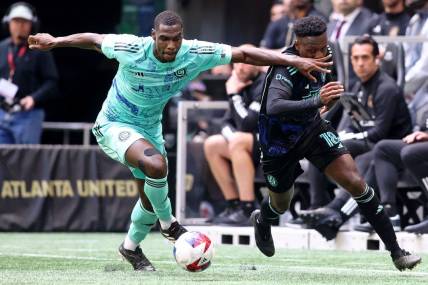 Apr 23, 2023; Atlanta, Georgia, USA; Chicago Fire defender Carlos Teran (4) battles for the ball against Atlanta United midfielder Derrick Etienne (18) during the first half at Mercedes-Benz Stadium. Mandatory Credit: Brett Davis-USA TODAY Sports