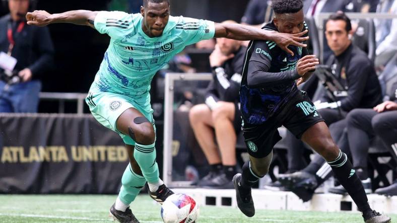 Apr 23, 2023; Atlanta, Georgia, USA; Chicago Fire defender Carlos Teran (4) battles for the ball against Atlanta United midfielder Derrick Etienne (18) during the first half at Mercedes-Benz Stadium. Mandatory Credit: Brett Davis-USA TODAY Sports