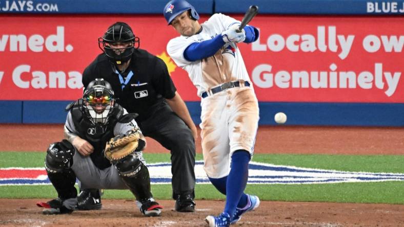 Apr 25, 2023; Toronto, Ontario, CAN;  Toronto Blue Jays right fielder George Springer (4) hits a single against the Chicago White Sox in the fourth inning at Rogers Centre. Mandatory Credit: Dan Hamilton-USA TODAY Sports