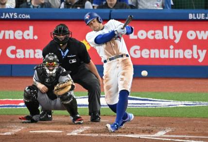 Apr 25, 2023; Toronto, Ontario, CAN;  Toronto Blue Jays right fielder George Springer (4) hits a single against the Chicago White Sox in the fourth inning at Rogers Centre. Mandatory Credit: Dan Hamilton-USA TODAY Sports