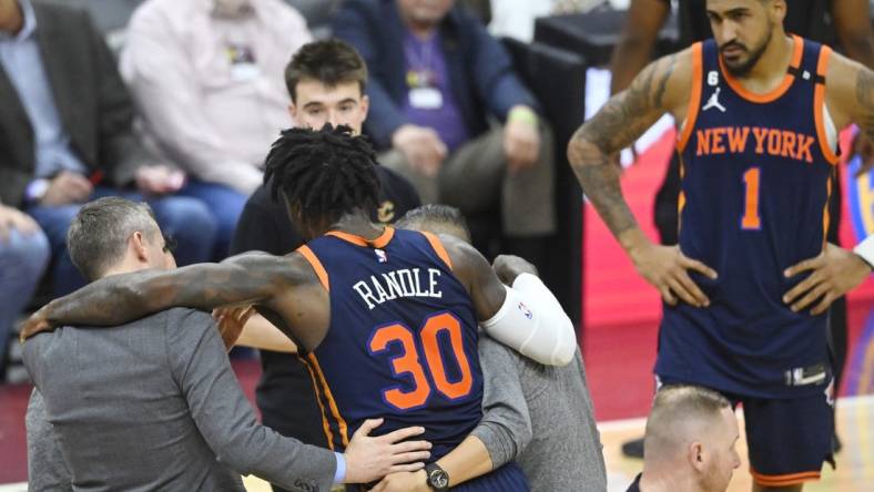 Apr 26, 2023; Cleveland, Ohio, USA; New York Knicks forward Julius Randle (30) is helped to his feet in the second quarter during game five of the 2023 NBA playoffs against the Cleveland Cavaliers at Rocket Mortgage FieldHouse. Mandatory Credit: David Richard-USA TODAY Sports