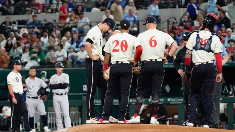 Apr 28, 2023; Arlington, Texas, USA; Texas Rangers starting pitcher Jacob deGrom (48) is visited on the mound by teammates and pitching coach pitching coach Mike Maddux (31) before leaving the game in the fourth inning against the New York Yankees at Globe Life Field. Mandatory Credit: Raymond Carlin III-USA TODAY Sports