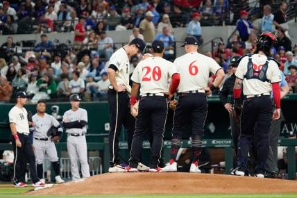 Apr 28, 2023; Arlington, Texas, USA; Texas Rangers starting pitcher Jacob deGrom (48) is visited on the mound by teammates and pitching coach pitching coach Mike Maddux (31) before leaving the game in the fourth inning against the New York Yankees at Globe Life Field. Mandatory Credit: Raymond Carlin III-USA TODAY Sports