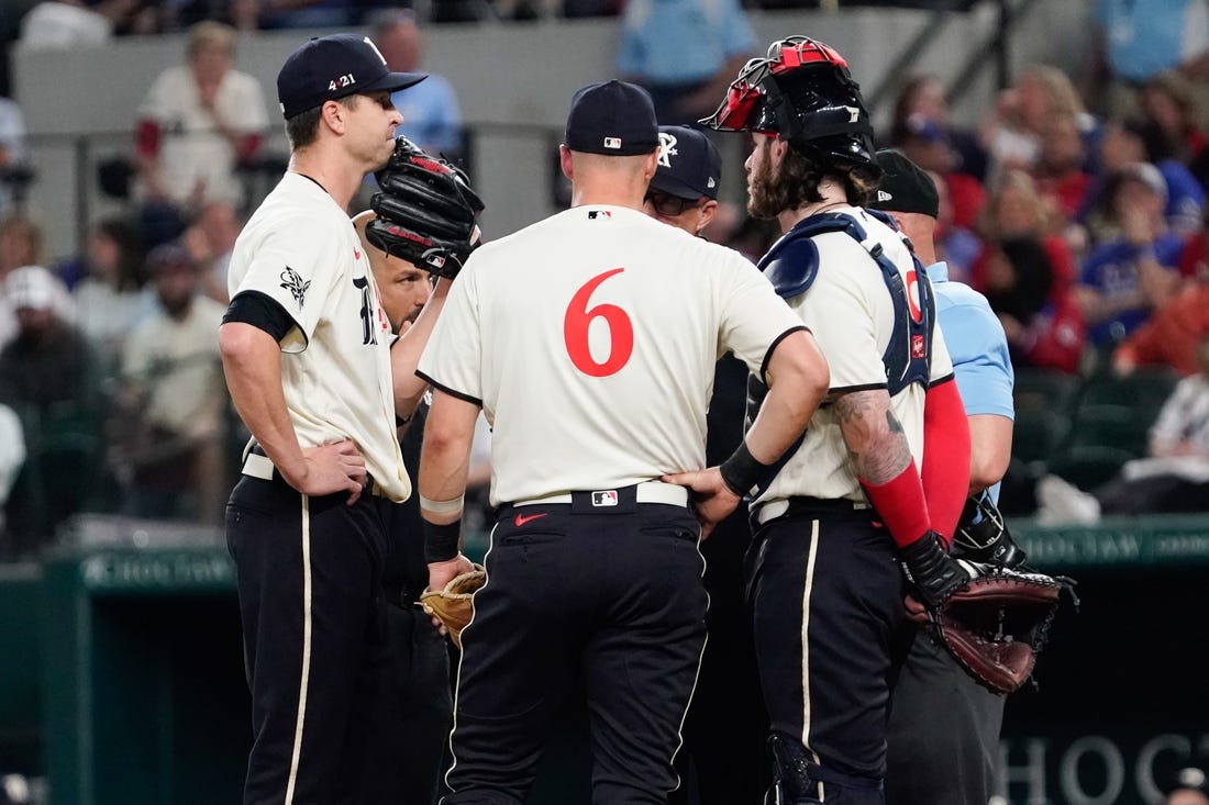 Apr 28, 2023; Arlington, Texas, USA; Texas Rangers starting pitcher Jacob deGrom (48) is visited on the mound by teammates and pitching coach pitching coach Mike Maddux (31) before leaving the game in the fourth inning against the New York Yankees at Globe Life Field. Mandatory Credit: Raymond Carlin III-USA TODAY Sports