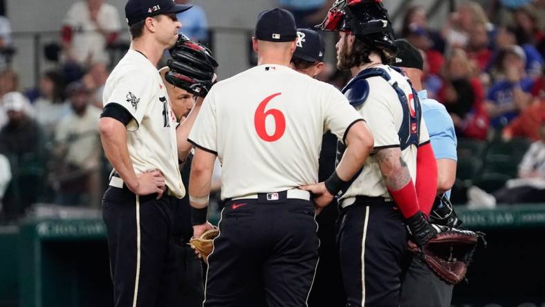 Apr 28, 2023; Arlington, Texas, USA; Texas Rangers starting pitcher Jacob deGrom (48) is visited on the mound by teammates and pitching coach pitching coach Mike Maddux (31) before leaving the game in the fourth inning against the New York Yankees at Globe Life Field. Mandatory Credit: Raymond Carlin III-USA TODAY Sports