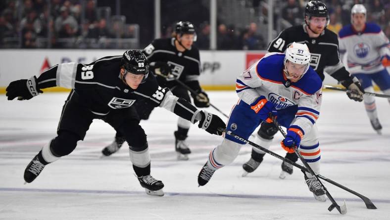 Apr 29, 2023; Los Angeles, California, USA; Edmonton Oilers center Connor McDavid (97) moves the puck against Los Angeles Kings center Rasmus Kupari (89) during the first period in game six of the first round of the 2023 Stanley Cup Playoffs at Crypto.com Arena. Mandatory Credit: Gary A. Vasquez-USA TODAY Sports