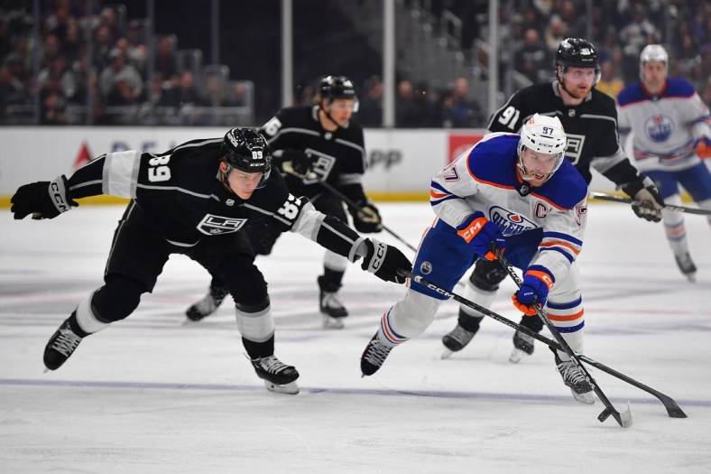 Apr 29, 2023; Los Angeles, California, USA; Edmonton Oilers center Connor McDavid (97) moves the puck against Los Angeles Kings center Rasmus Kupari (89) during the first period in game six of the first round of the 2023 Stanley Cup Playoffs at Crypto.com Arena. Mandatory Credit: Gary A. Vasquez-USA TODAY Sports