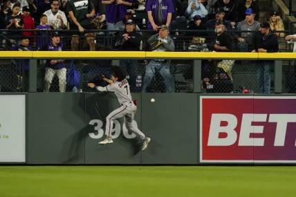 Apr 29, 2023; Denver, Colorado, USA;  Arizona Diamondbacks left fielder Corbin Carroll (7) falls after banging into the outfield wall at Coors Field.  Carroll left the game after the play. Mandatory Credit: Michael Madrid-USA TODAY Sports