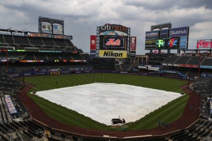 Jul 8, 2021; New York City, New York, USA; A tarp covers the infield prior to the game between the Pittsburgh Pirates and the New York Mets being postponed at Citi Field. Mandatory Credit: Wendell Cruz-USA TODAY Sports