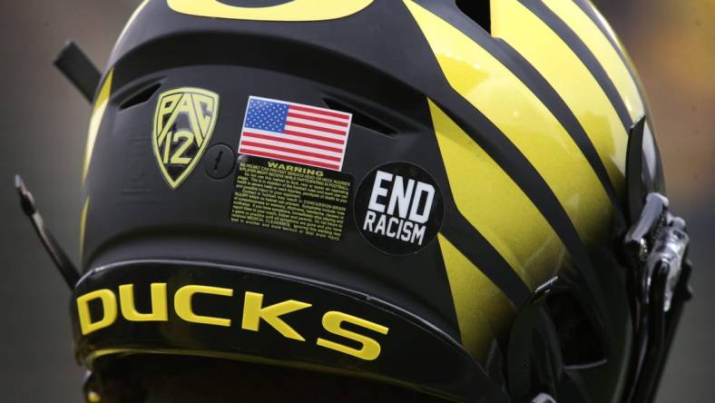 An "End racism" sticker joins the American Flag on the helmets of Oregon players Saturday Oct. 30, 2021.

Eug 103021 Uo Cofb03