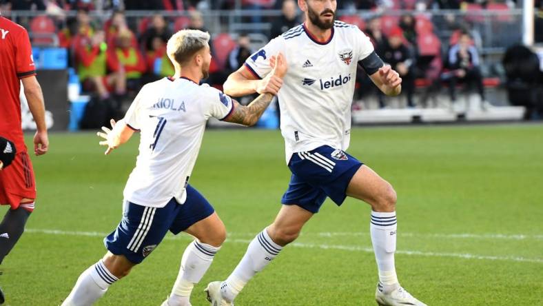 Nov 7, 2021; Toronto, Ontario, CAN;   DC United defender Steven Birnbaum (15) celebrates with forward Paul Arriola (7) after scoring on a header against Toronto FC in the first half at BMO Field. Mandatory Credit: Dan Hamilton-USA TODAY Sports