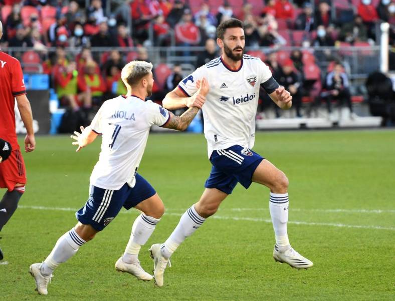 Nov 7, 2021; Toronto, Ontario, CAN;   DC United defender Steven Birnbaum (15) celebrates with forward Paul Arriola (7) after scoring on a header against Toronto FC in the first half at BMO Field. Mandatory Credit: Dan Hamilton-USA TODAY Sports