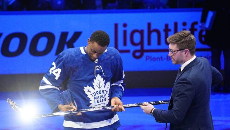 Mar 8, 2022; Toronto, Ontario, CAN; Toronto Maple Leafs general manager Kyle Dubas (right) presents forward Wayne Simmonds (24) with a silver stick after having played in his 1,000th game before a game against the Seattle Kraken at Scotiabank Arena. Mandatory Credit: John E. Sokolowski-USA TODAY Sports