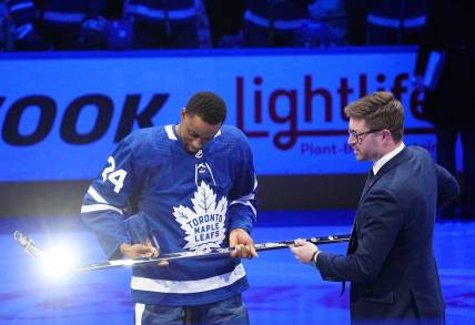 Mar 8, 2022; Toronto, Ontario, CAN; Toronto Maple Leafs general manager Kyle Dubas (right) presents forward Wayne Simmonds (24) with a silver stick after having played in his 1,000th game before a game against the Seattle Kraken at Scotiabank Arena. Mandatory Credit: John E. Sokolowski-USA TODAY Sports