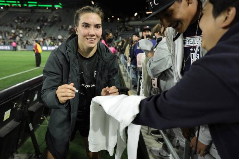 May 21, 2022; Los Angeles, California, USA; Angel City FC defender Vanessa Giles (4) signs autographs after the win against the Kansas City Current at Banc of California Stadium. Mandatory Credit: Kirby Lee-USA TODAY Sports