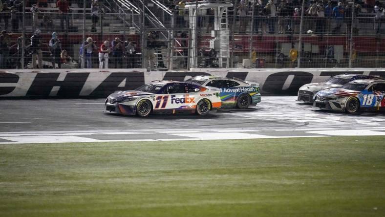 May 29, 2022; Concord, North Carolina, USA; NASCAR Cup Series driver Denny Hamlin (11) takes the lead on the restart in the Coca-Cola 600 at Charlotte Motor Speedway. Mandatory Credit: Jim Dedmon-USA TODAY Sports