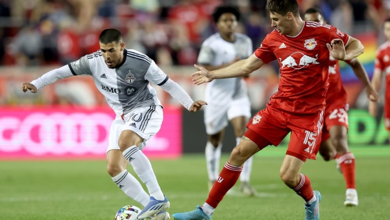 Jun 18, 2022; Harrison, New Jersey, USA; Toronto FC midfielder Alejandro Pozuelo (10) controls the ball against New York Red Bulls defender Sean Nealis (15) during the second half at Red Bull Arena. Mandatory Credit: Brad Penner-USA TODAY Sports