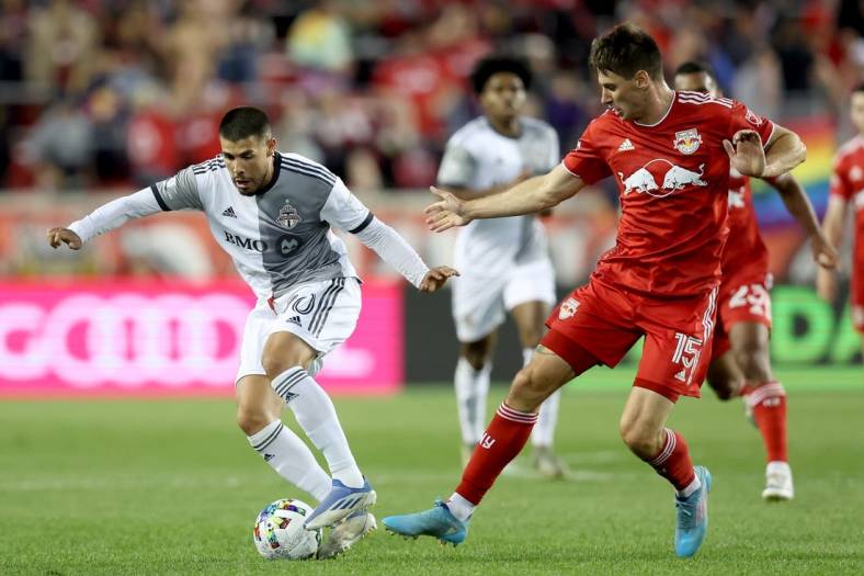 Jun 18, 2022; Harrison, New Jersey, USA; Toronto FC midfielder Alejandro Pozuelo (10) controls the ball against New York Red Bulls defender Sean Nealis (15) during the second half at Red Bull Arena. Mandatory Credit: Brad Penner-USA TODAY Sports