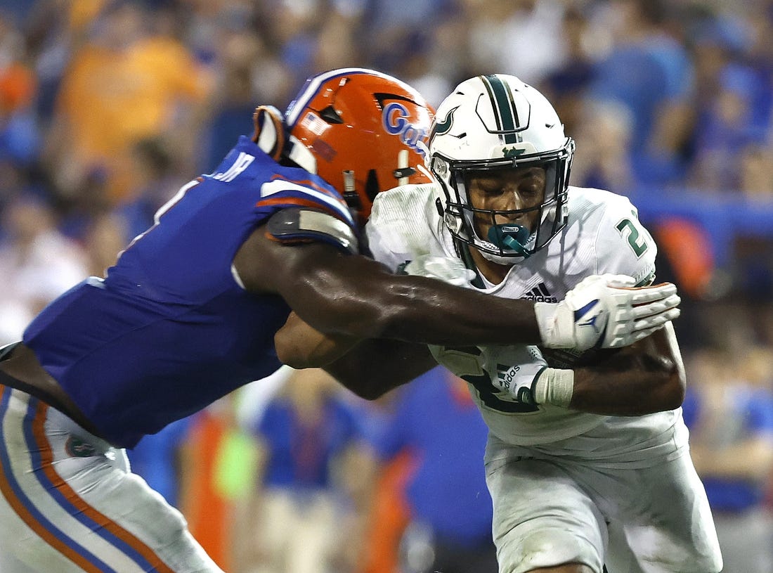 Sep 17, 2022; Gainesville, Florida, USA; South Florida Bulls running back Michel Dukes (2) runs with the ball as Florida Gators linebacker Brenton Cox Jr. (1) defends during the second half at Ben Hill Griffin Stadium. Mandatory Credit: Kim Klement-USA TODAY Sports