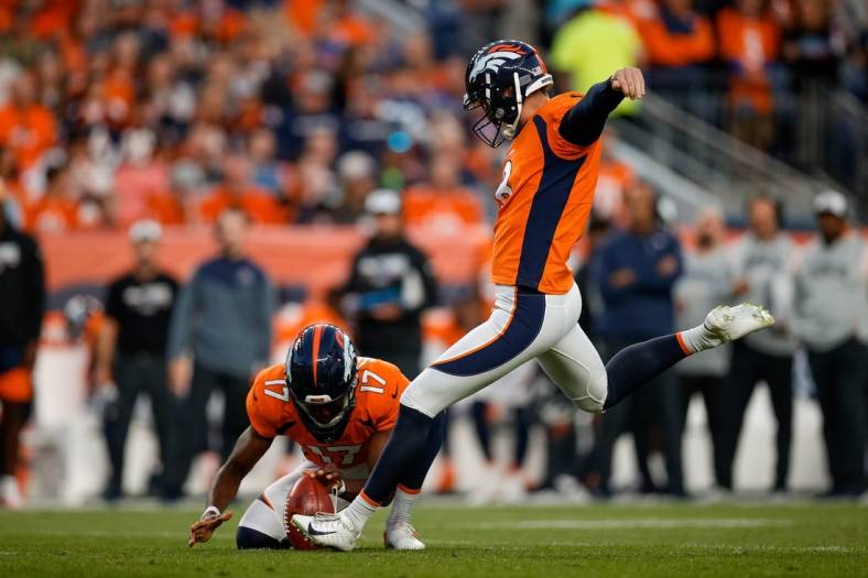 Oct 6, 2022; Denver, Colorado, USA; Denver Broncos place kicker Brandon McManus (8) kicks a field goal on a hold from punter Corliss Waitman (17) in the first quarter against the Indianapolis Colts at Empower Field at Mile High. Mandatory Credit: Isaiah J. Downing-USA TODAY Sports