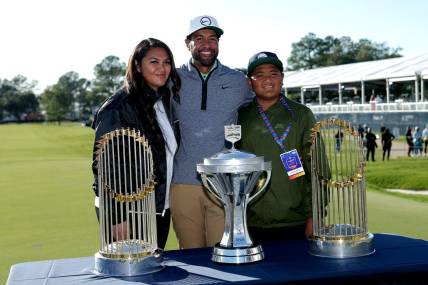 Nov 13, 2022; Houston, Texas, USA; Tony Finau poses for a photo with his family with the championship trophy and both Houston Astros world championship trophies after winning the Cadence Bank Houston Open golf tournament. Mandatory Credit: Erik Williams-USA TODAY Sports