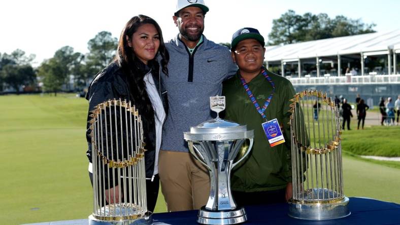 Nov 13, 2022; Houston, Texas, USA; Tony Finau poses for a photo with his family with the championship trophy and both Houston Astros world championship trophies after winning the Cadence Bank Houston Open golf tournament. Mandatory Credit: Erik Williams-USA TODAY Sports