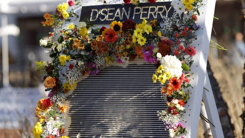 Nov 19, 2022; Charlottesville, Virginia, US; A partial view of a flower board with an image of D'Sean Perry, one of three Virginia Cavaliers football players killed in a campus shooting on November 13th is displayed prior to the start of a memorial at John Paul Jones Arena. Mandatory Credit: Geoff Burke-USA TODAY Sports