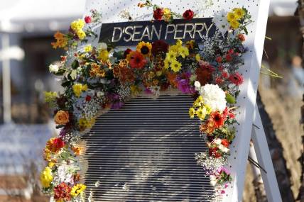 Nov 19, 2022; Charlottesville, Virginia, US; A partial view of a flower board with an image of D'Sean Perry, one of three Virginia Cavaliers football players killed in a campus shooting on November 13th is displayed prior to the start of a memorial at John Paul Jones Arena. Mandatory Credit: Geoff Burke-USA TODAY Sports