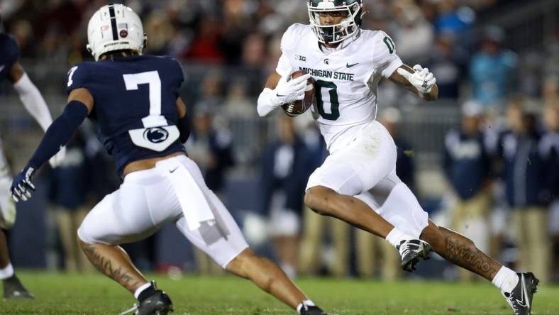 Nov 26, 2022; University Park, Pennsylvania, USA; Michigan State Spartans wide receiver Keon Coleman (0) runs the ball against Penn State Nittany Lions safety Jaylen Reed (7) during the fourth quarter at Beaver Stadium. Penn State won 35-16. Mandatory Credit: Matthew OHaren-USA TODAY Sports