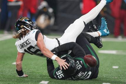 Dec 22, 2022; East Rutherford, New Jersey, USA; Jacksonville Jaguars quarterback Trevor Lawrence (16) is sacked by New York Jets defensive tackle Quinnen Williams (95) during the first half at MetLife Stadium. Mandatory Credit: Vincent Carchietta-USA TODAY Sports