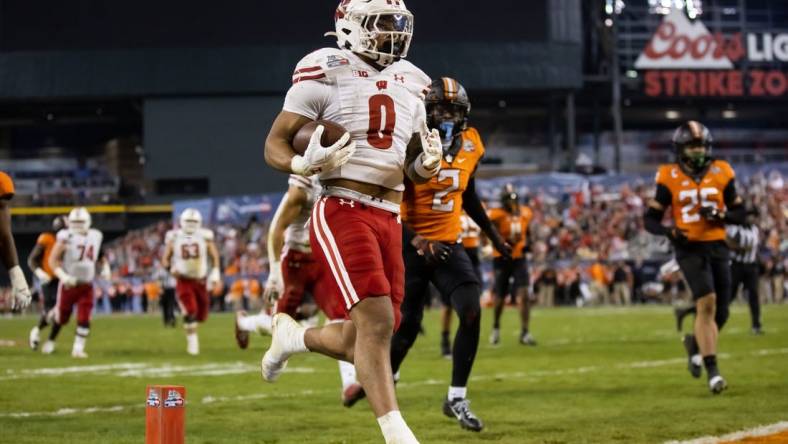 Dec 27, 2022; Phoenix, Arizona, USA; Wisconsin Badgers running back Braelon Allen (0) runs the ball for a touchdown against the Oklahoma State Cowboys in the second half of the 2022 Guaranteed Rate Bowl at Chase Field. Mandatory Credit: Mark J. Rebilas-USA TODAY Sports