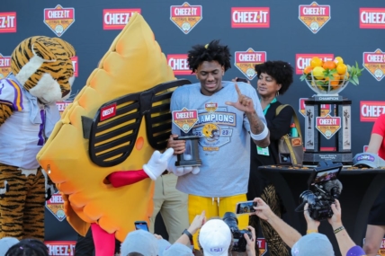Jan 2, 2023; Orlando, FL, USA; LSU Tigers wide receiver Malik Nabers (8) is presented with most valuable player trophy by Cheez-it mascot after the game against the Purdue Boilermakers at Camping World Stadium. Mandatory Credit: Mike Watters-USA TODAY Sports