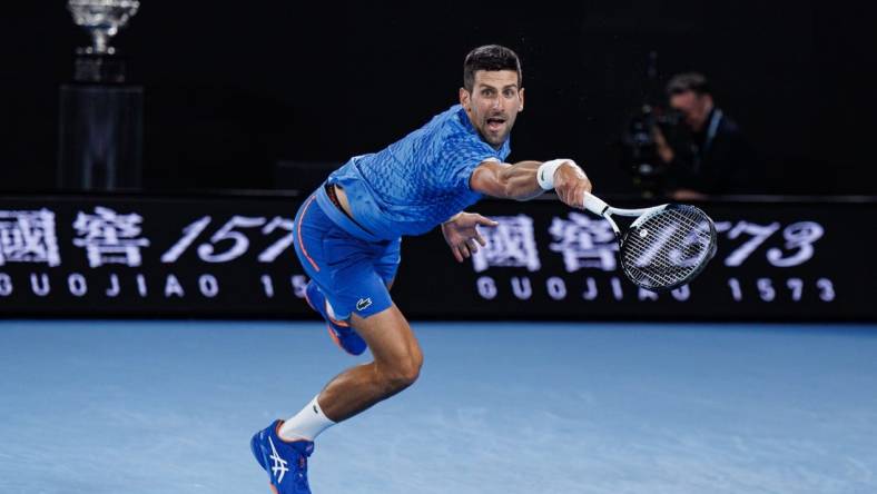 Jan 29, 2023; Melbourne, Victoria, Australia; Novak Djokovic of Serbia hits a shot against Stefanos Tsitsipas of Greece at the men's final on day fourteen of the 2023 Australian Open tennis tournament at Melbourne Park. Mandatory Credit: Mike Frey-USA TODAY Sports