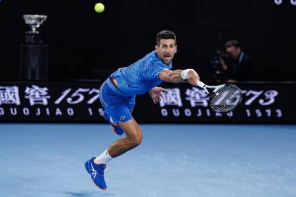 Jan 29, 2023; Melbourne, Victoria, Australia; Novak Djokovic of Serbia hits a shot against Stefanos Tsitsipas of Greece at the men's final on day fourteen of the 2023 Australian Open tennis tournament at Melbourne Park. Mandatory Credit: Mike Frey-USA TODAY Sports