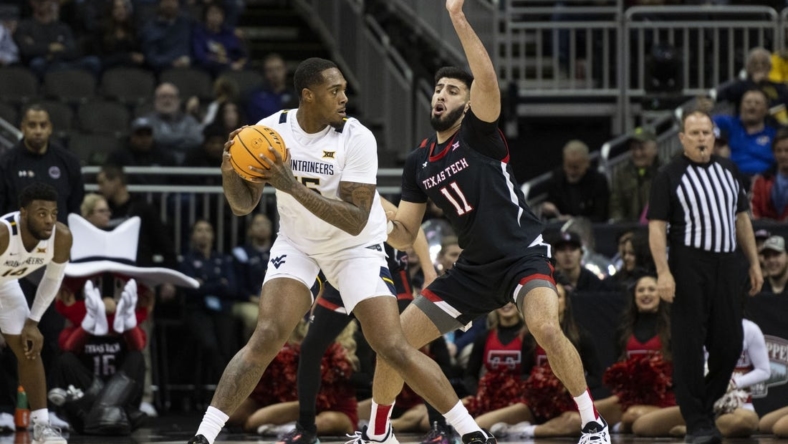 Mar 8, 2023; Kansas City, MO, USA; West Virginia Mountaineers forward Jimmy Bell Jr. (15) handles the ball while defended by Texas Tech Red Raiders forward Fardaws Aimaq (11) in the first half at T-Mobile Center. Mandatory Credit: Amy Kontras-USA TODAY Sports