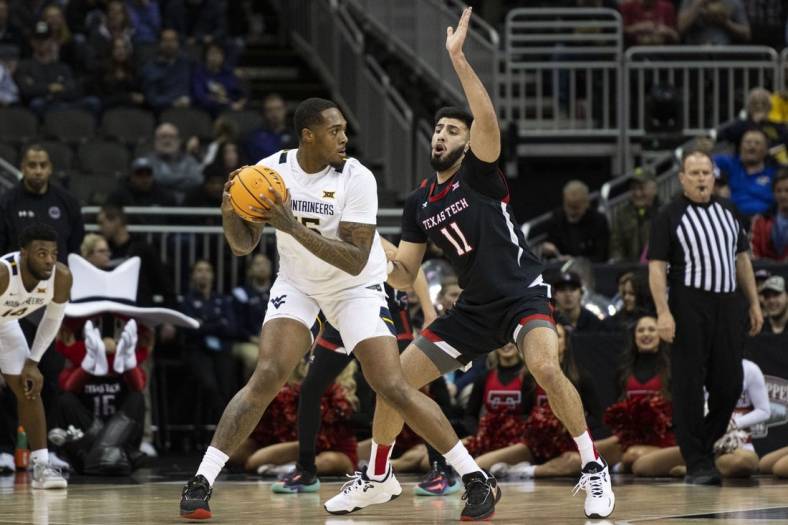 Mar 8, 2023; Kansas City, MO, USA; West Virginia Mountaineers forward Jimmy Bell Jr. (15) handles the ball while defended by Texas Tech Red Raiders forward Fardaws Aimaq (11) in the first half at T-Mobile Center. Mandatory Credit: Amy Kontras-USA TODAY Sports