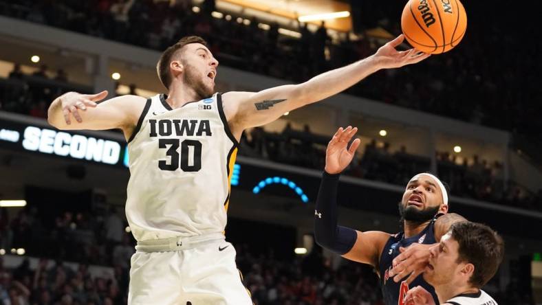 Mar 16, 2023; Birmingham, AL, USA; Iowa Hawkeyes guard Connor McCaffery (30) reaches for a rebound against Auburn Tigers forward Johni Broome (4) during the second half in the first round of the 2023 NCAA Tournament at Legacy Arena. Mandatory Credit: Marvin Gentry-USA TODAY Sports