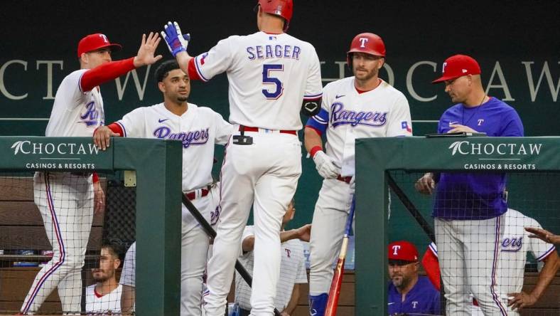 Apr 10, 2023; Arlington, Texas, USA; Texas Rangers shortstop Corey Seager (5) is greeted at the dugout after hitting a solo home run during the first inning against the Kansas City Royals at Globe Life Field. Mandatory Credit: Raymond Carlin III-USA TODAY Sports