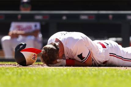 Apr 12, 2023; Minneapolis, Minnesota, USA; Minnesota Twins second baseman Kyle Farmer (12) drops to the ground after getting hit by a pitch in the face by the Chicago White Sox in the fourth inning at Target Field. Mandatory Credit: Bruce Kluckhohn-USA TODAY Sports