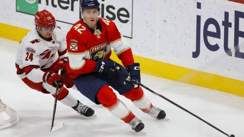 Apr 13, 2023; Sunrise, Florida, USA; Florida Panthers defenseman Gustav Forsling (42) moves the puck ahead of Carolina Hurricanes center Seth Jarvis (24) during the second period at FLA Live Arena. Mandatory Credit: Sam Navarro-USA TODAY Sports