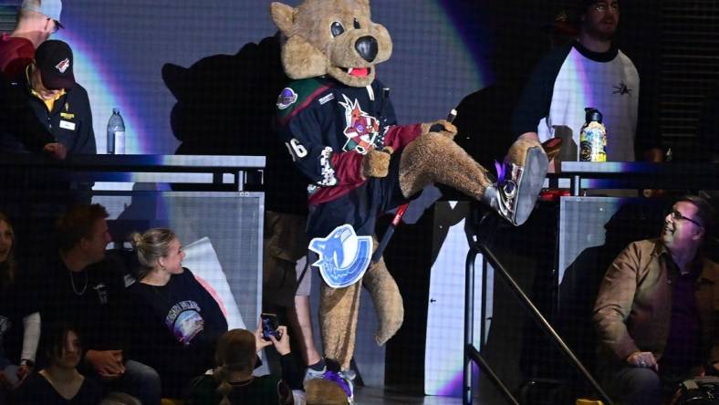 Arizona Coyotes mascot Howler breaks a Vancouver Canucks stick over his leg in the first period at Mullett Arena. Mandatory Credit: Matt Kartozian-USA TODAY Sports