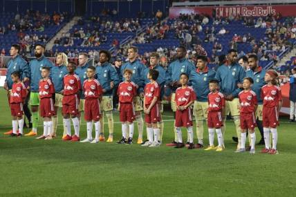 Apr 15, 2023; Harrison, New Jersey, USA; New York Red Bulls players stand with young fans during the national anthem before the game against the Houston Dynamo at Red Bull Arena. Mandatory Credit: Vincent Carchietta-USA TODAY Sports