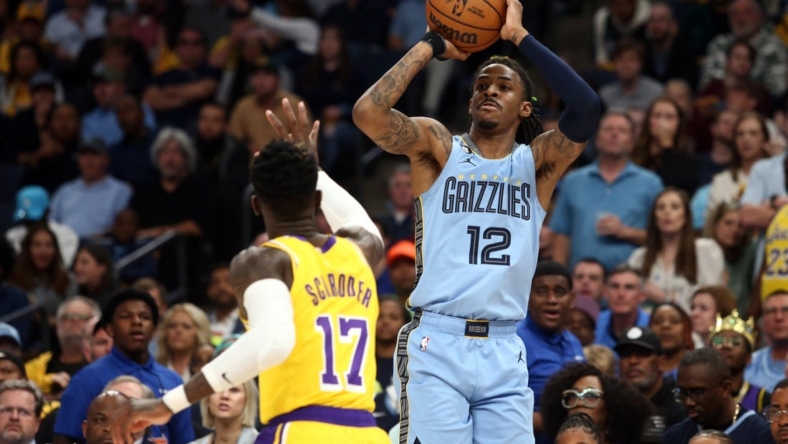 Apr 26, 2023; Memphis, Tennessee, USA; Memphis Grizzlies guard Ja Morant (12) shoots a three point shot as Los Angeles Lakers guard Dennis Schroder (17) defends during the second half of game five of the 2023 NBA playoffs at FedExForum. Mandatory Credit: Petre Thomas-USA TODAY Sports