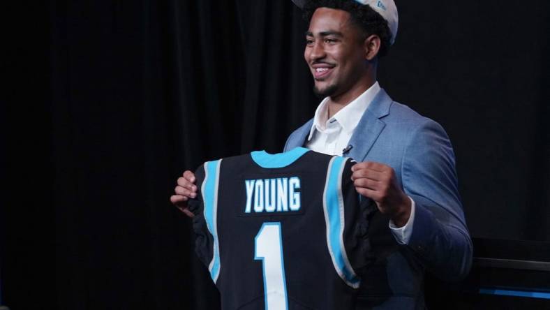 Apr 28, 2023; Charlotte, NC, USA; Bryce Young holds up a jersey depicting his draft position at Bank of America Stadium. Mandatory Credit: Jim Dedmon-USA TODAY Sports