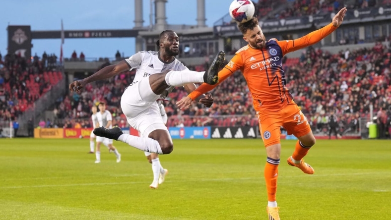Apr 29, 2023; Toronto, Ontario, CAN; Toronto FC forward Charles Sapong (9) battles for the ball against New York City FC forward Kevin O'Toole (22) during the first half at BMO Field. Mandatory Credit: Nick Turchiaro-USA TODAY Sports