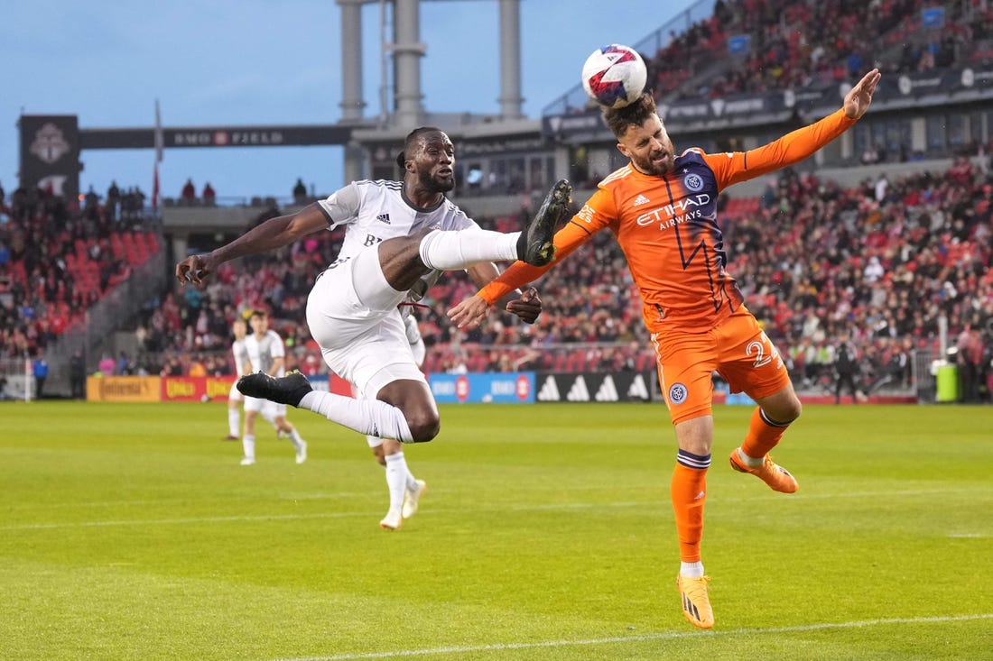 Apr 29, 2023; Toronto, Ontario, CAN; Toronto FC forward Charles Sapong (9) battles for the ball against New York City FC forward Kevin O'Toole (22) during the first half at BMO Field. Mandatory Credit: Nick Turchiaro-USA TODAY Sports