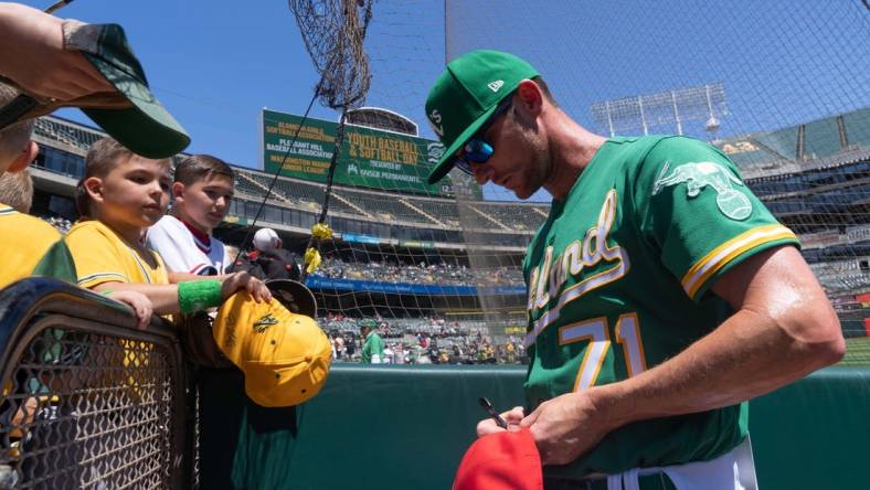 Apr 30, 2023; Oakland, California, USA;  Oakland Athletics bullpen coach Mike McCarthy (71) signs autographs for fans before the start of the first inning against the Cincinnati Reds at RingCentral Coliseum. Mandatory Credit: Stan Szeto-USA TODAY Sports