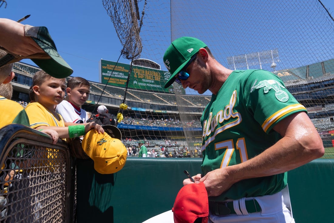 Apr 30, 2023; Oakland, California, USA;  Oakland Athletics bullpen coach Mike McCarthy (71) signs autographs for fans before the start of the first inning against the Cincinnati Reds at RingCentral Coliseum. Mandatory Credit: Stan Szeto-USA TODAY Sports
